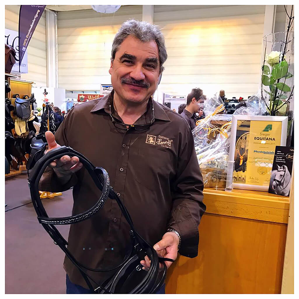 Auf dem Bild ist Herr Jochen Hennig auf dem Hennig Messestand zu sehen. In der Hand hält eine Free Motion System Trense, für die er den Innovationspreis der Equitana 2017 gewonnen hat.